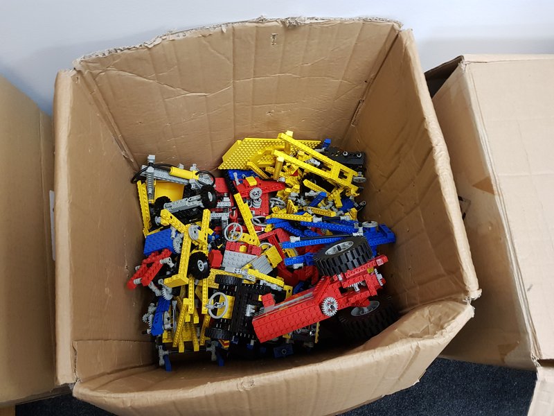 A large cardboard box full of Lego pieces.
