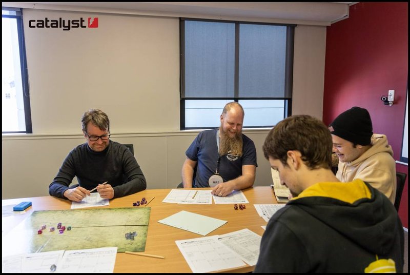 Several people are sitting round a table playing Dungeons and Dragons.