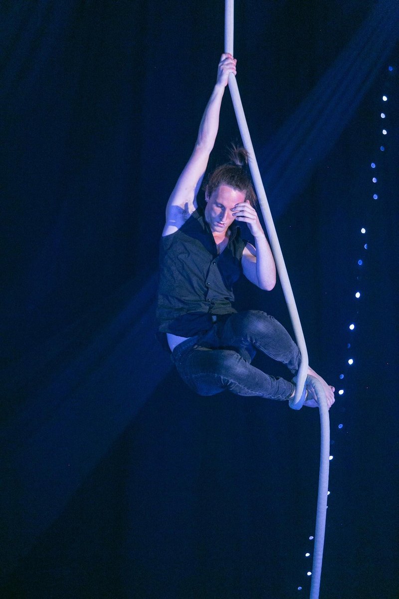 Liam Sharpe performing aerial rope with dramatic lighting