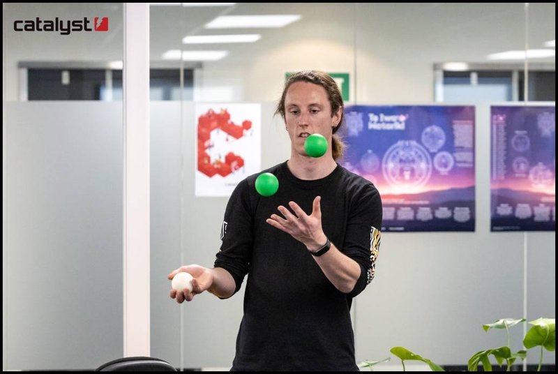 A person is juggling balls in an office.